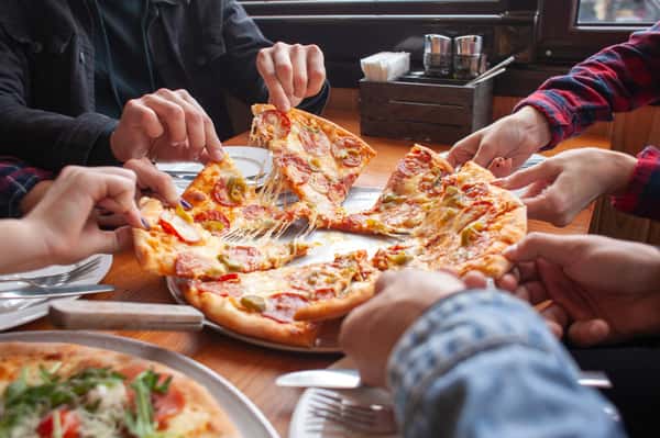group-students-friends-eat-italian-pizza-hands-take-slices-pizza-restaurant