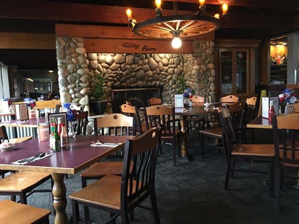 dining room area setup with tables and chairs with a fire place