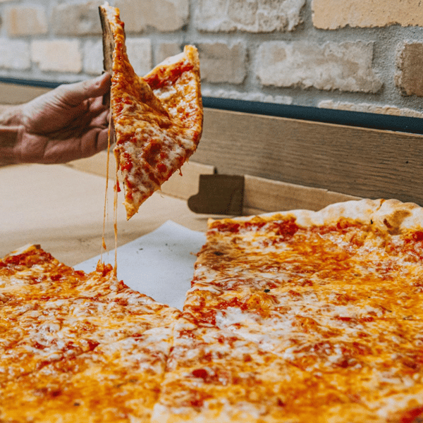 Hand grabbing a slice of pizza