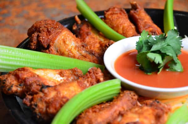 Crispy chicken wings served with celery sticks and dipping sauce.