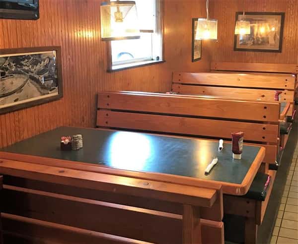 Dining area with table that contains napkins untensils and ketchup