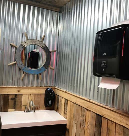 Sailer themed bathroom with boat steering wheel mirror