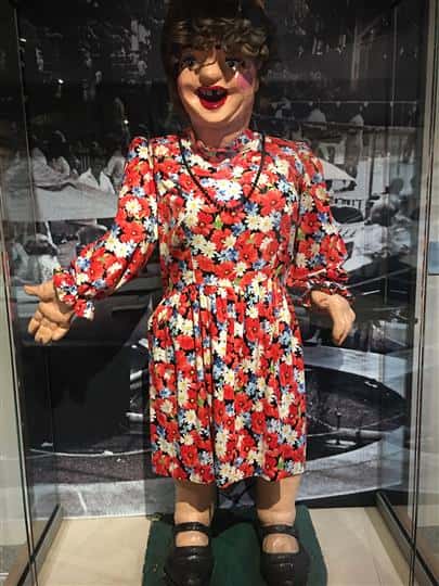 Statue of a women wearing a flower dress in a glass display case