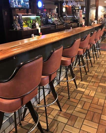 Empty barstool seats at a bar