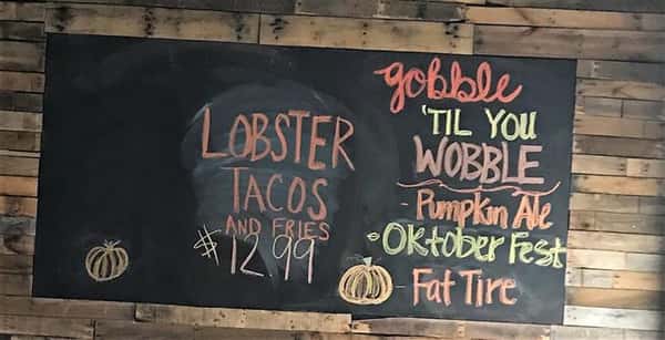 Sign that reads "Lobster Tacos and Fries $12.99" for an october themed promotion