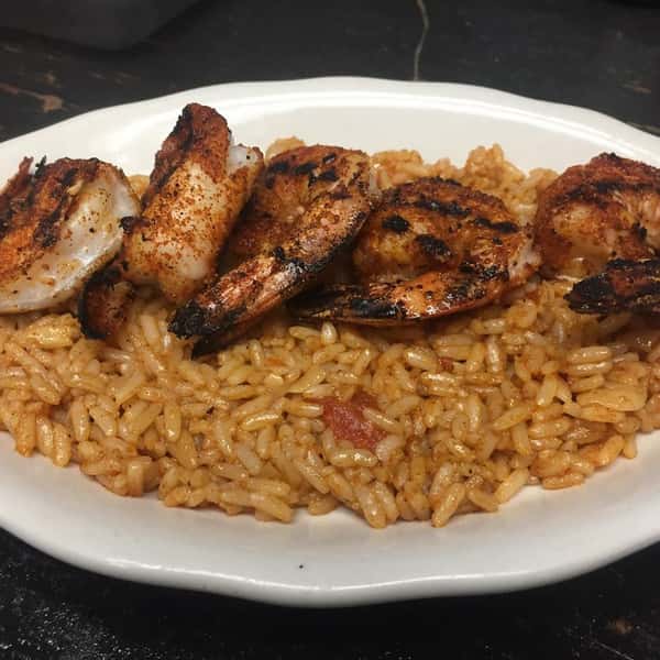 Rice topped with blackened and seasoned shrimp