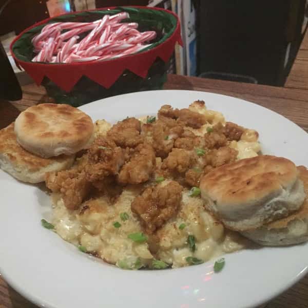 Macaroni an cheese topped with popcorn shrimp and a side of biscuits