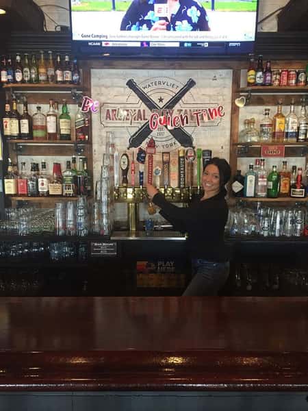 A bartender standing in front of the tap beer options