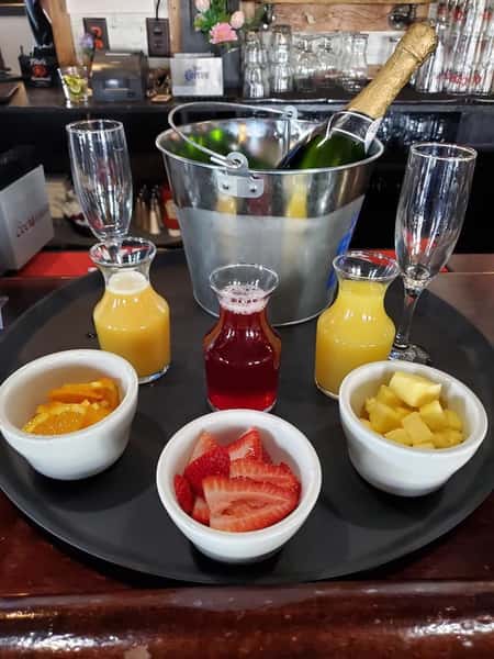 A mimosa display with juices and fruit at a catered event