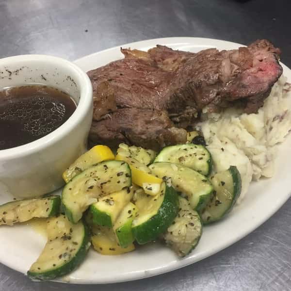 Beef with a side of mashed potatoes and grilled vegetables