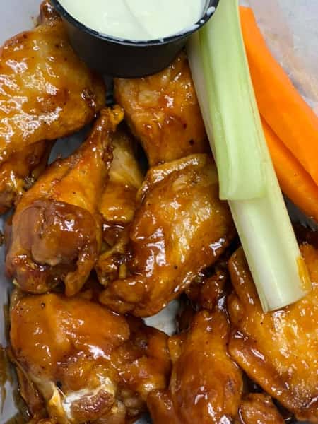 BBQ chicken wings with a side of blue cheese, celery, and carrots