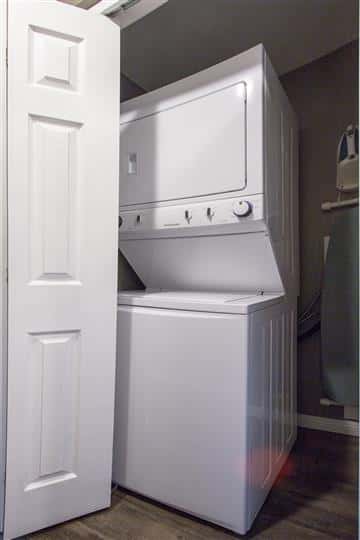 Washer - dryer unit in room next to door