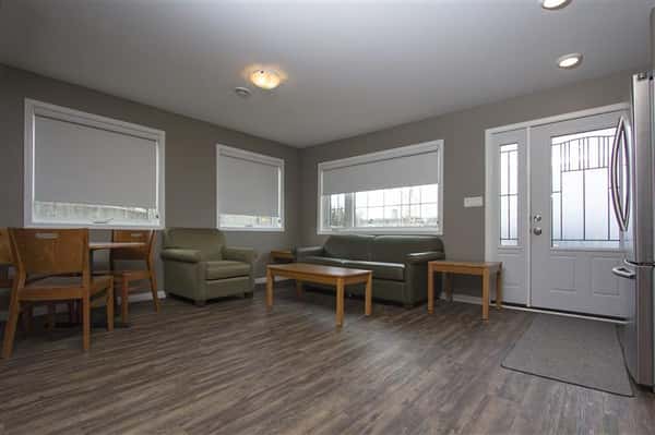 Room with wood floors, couch, wood end tables, wood coffee table, wood round table and wood chairs.