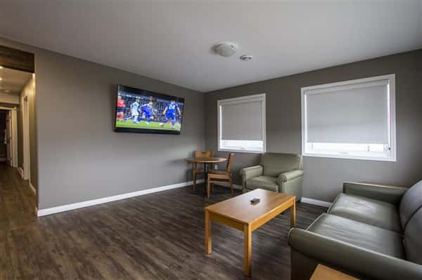 Room with wood floor, couch, chair, wood coffee table, wood dining table and chairs.