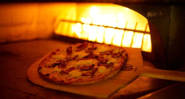 Pizza cooking in fire oven