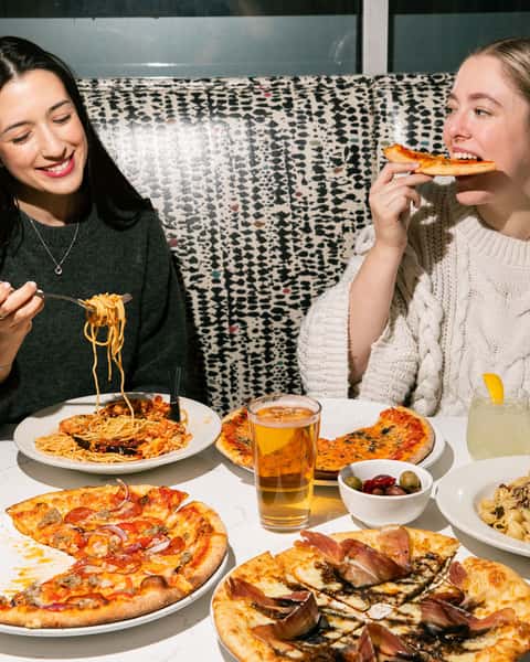 Friends enjoying a delicious Italian meal at Osteria 832