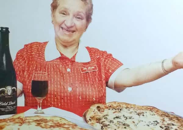 Kitty with pizzas in front