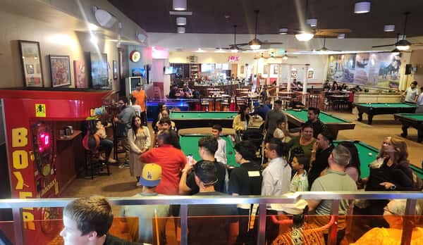 People Love to Compete Puncing the Boxing Over a Dozen People Watching in the Pool Hall