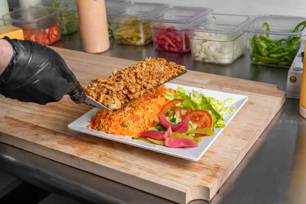 Chef adding a meat to a saqlad
