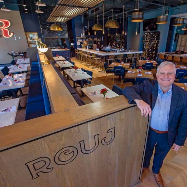 Man leaning on counter in Rouj restaurant