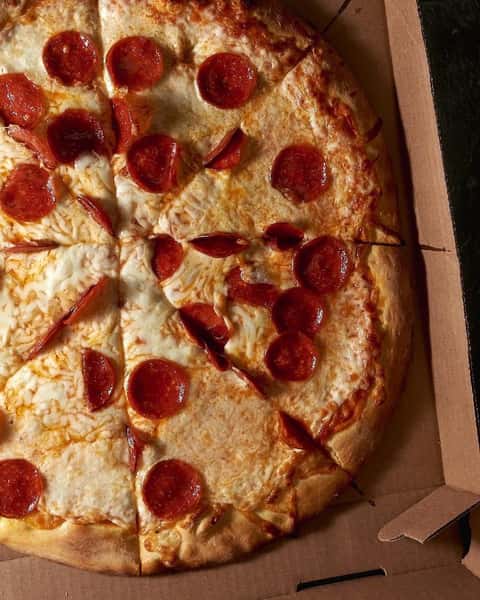 Classic pepperoni pizza with a golden crust, topped with melted mozzarella cheese and crispy pepperoni slices, served in a cardboard takeout box.