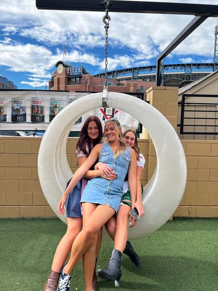 Friends posing on the ViewHouse rooftop patio with stadium views, creating memorable moments in a lively social and entertainment setting.