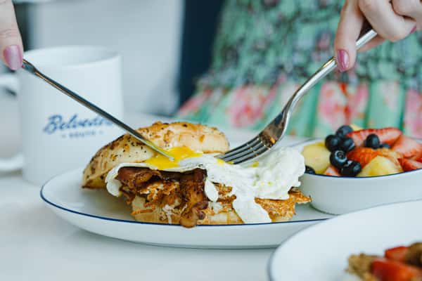 A fried egg topped with ham or bacon, cheese, and fried tomatoes with Parmesan served on an onion roll. Protein choice: Ham, bacon