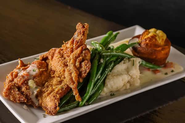 Crispy fried chicken served with greens and a mash side