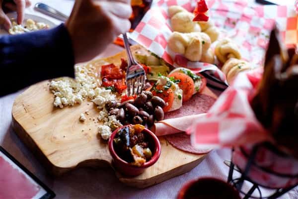 Wooden board with a variety of deli snacks served on the table