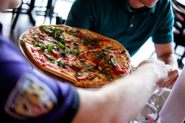 Close up of a pizza being served at the table