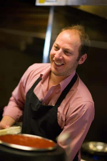 Man wearing an apron smiling for photo