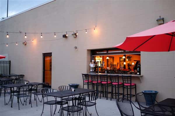 Exterior photo of the bar from the patio with red umbrellas