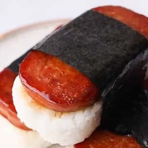 Classic Hawaiian Spam musubi made with seared Spam slices atop white rice, wrapped tightly with a strip of nori seaweed – a popular island snack or lunch bite.
