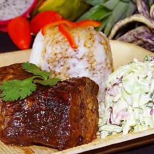 Tender barbecue short ribs glazed in savory sauce, plated with creamy cabbage slaw and a scoop of white rice, garnished with red peppers and cilantro – a hearty Hawaiian-inspired plate lunch.
