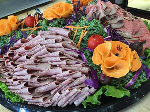 catering platter with cold cuts, and decorated veggies