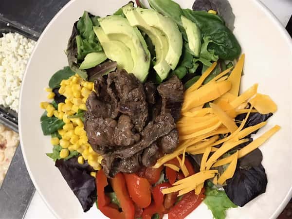 salad with steak, cheddar, avocado, corn, and peppers