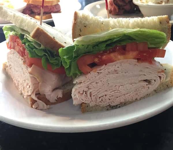 turkey club sandwich with lettuce and tomato