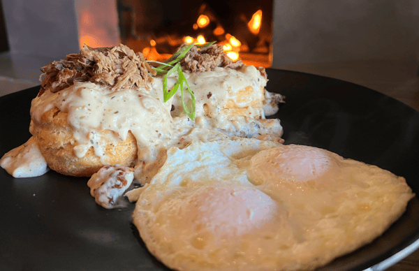 Saucy meat dish with sunny side up eggs on the side