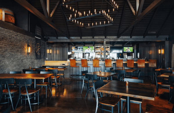 Whiskey 'N Rye bar area with TV's and dark wood tables and chairs