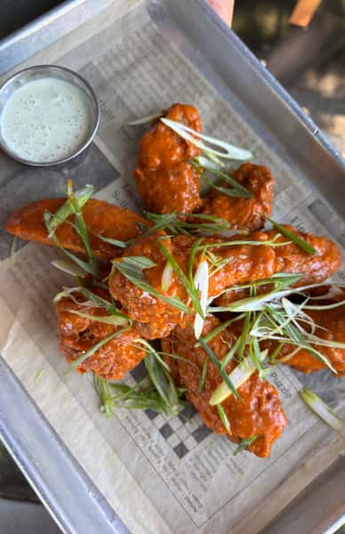 Dunked meat strips topped with garnish and served with a sauce
