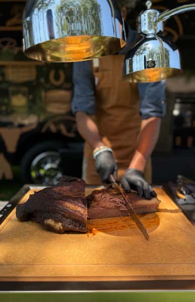 Chef slicing up pieces of meat in a kitchen