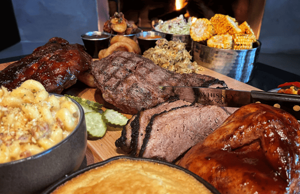 Meat and sides spread on a wooden board
