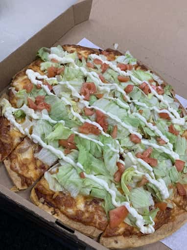 Pizza with lettuce tomato and dressing