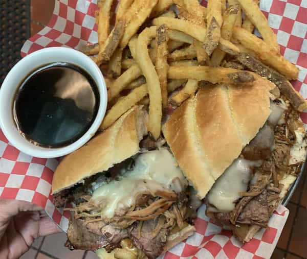 pulled pork and cheese sandwich with fries and dipping sauce on the side