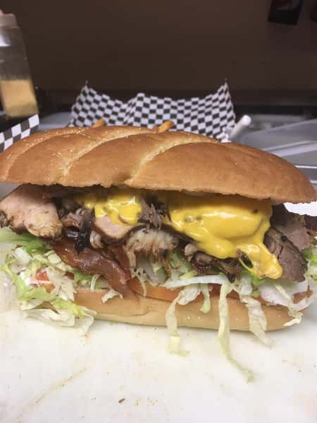 a sub with brisket, cheese, bacon, and lettuce