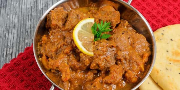 Curry in a dish with a lemon slice