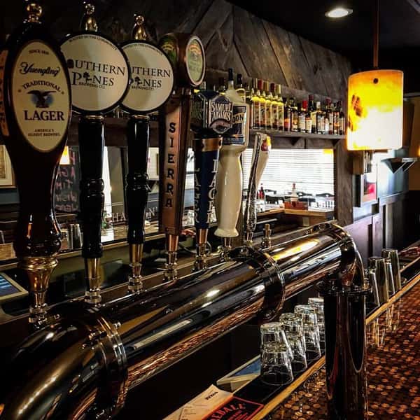 Row of beer taps at bar. Yuengling, Southern Pines, Sierra, Sam Adams, Blue Moon