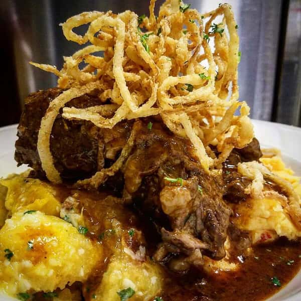 Meatloaf with gravy and onion straws over mashed potatoes