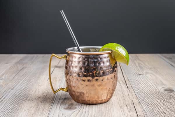 Texas Mule cocktail served in a hammered copper mug with a fresh lime garnish at Spechts Texas Bar & Grill.