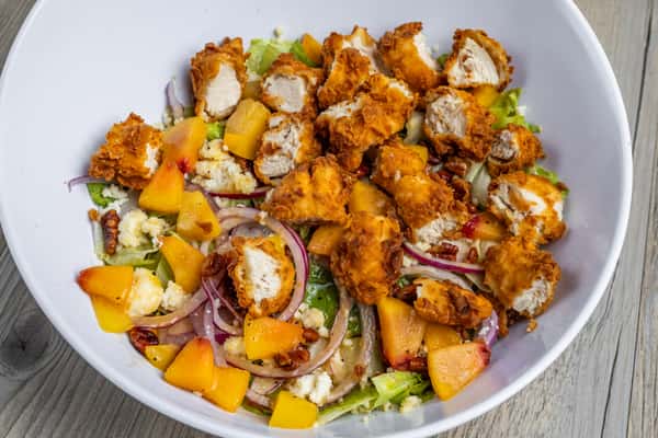Fresh peach salad with grilled chicken, greens, fruit, and creamy dressing at Spechts Texas Bar & Grill.